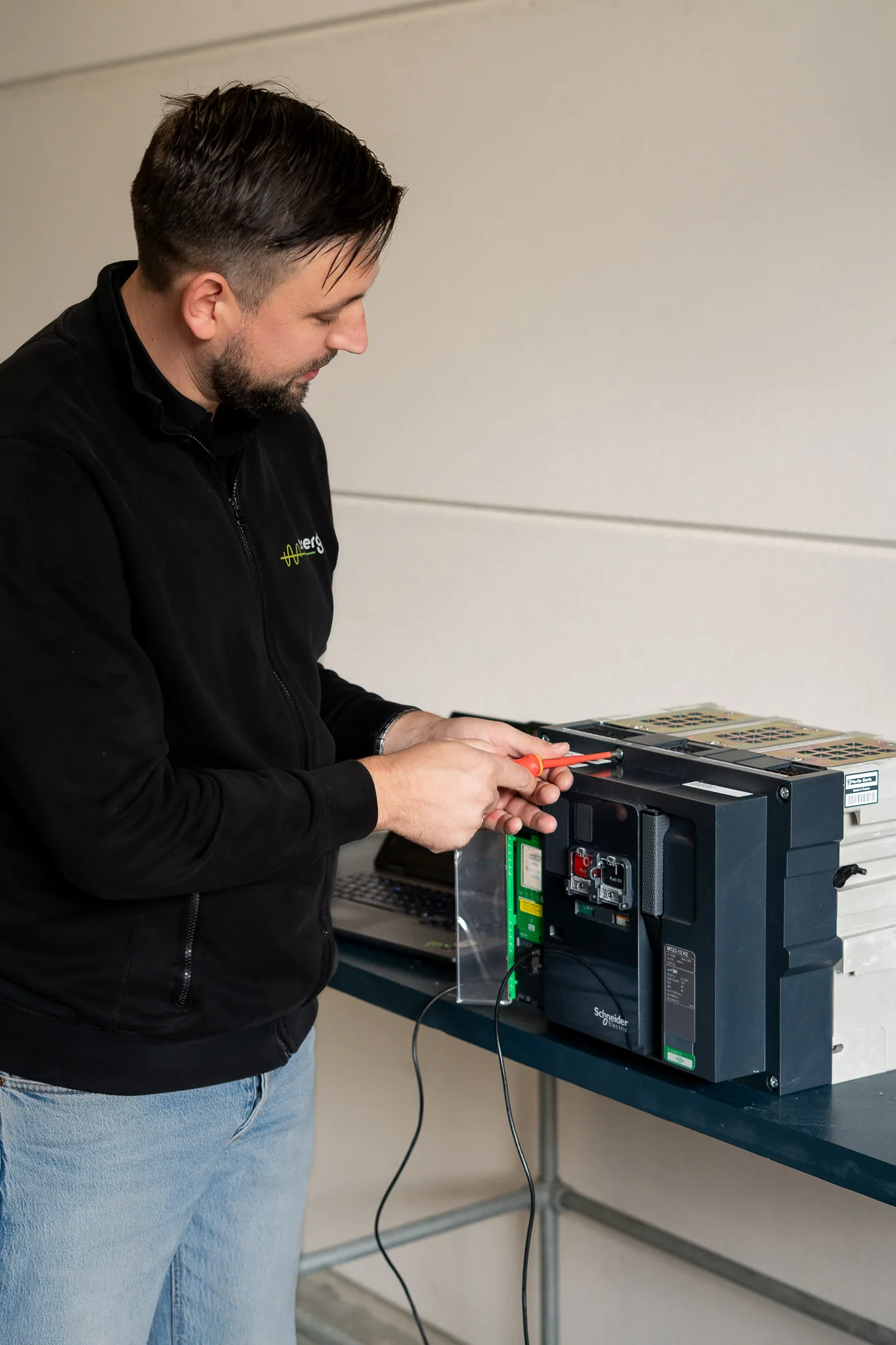Sin-Ergy-specialist werkt aan een Schneider Electric vermogensautomaat